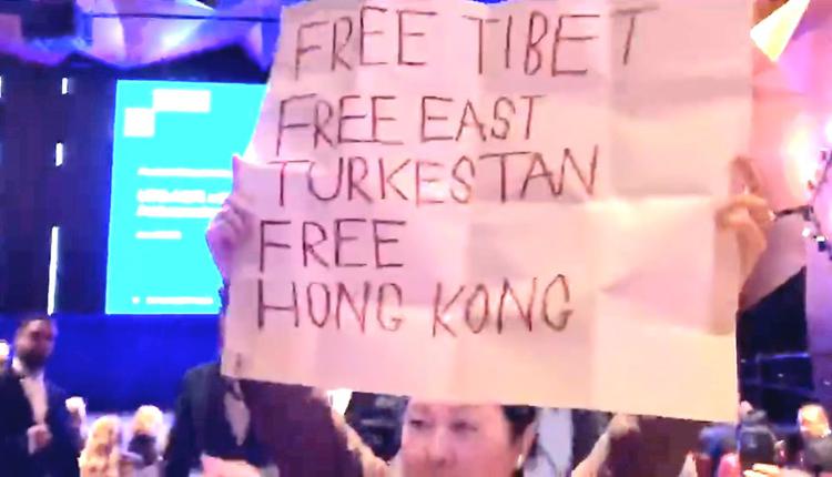 抗议者举着写着“自由西藏”和“自由香港”的标语
